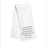 White kitchen towel with black text reading “A good friend knows all your stories. A great friend helped you write them.”