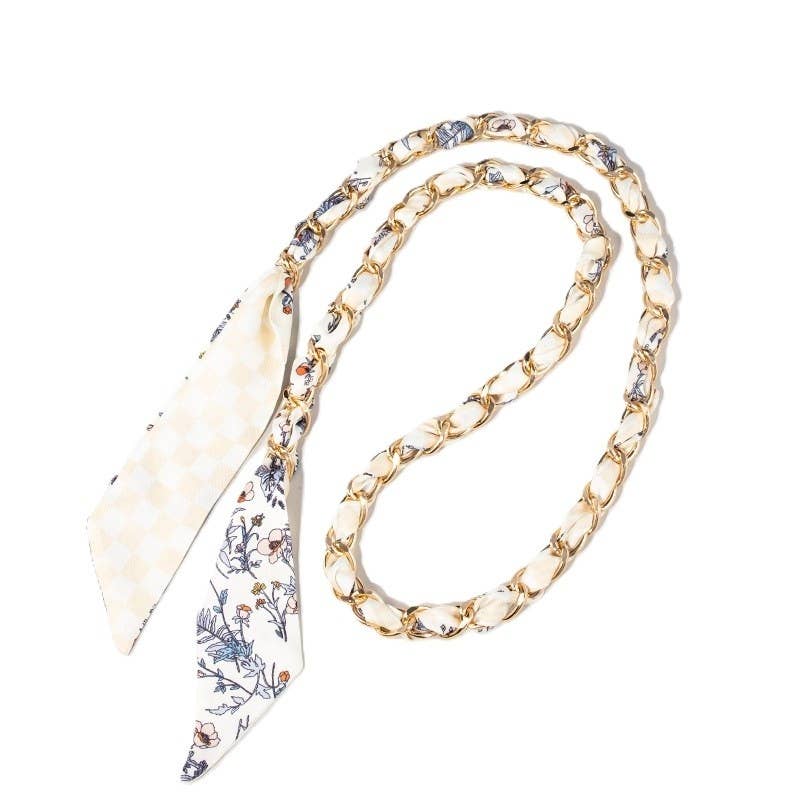 Double-sided cream checkered and floral scarf woven through gold chain bag strap.
