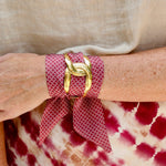 Garnet scarf bracelet with white geometric pattern threaded through adjustable stainless steel cuff