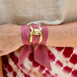 Garnet scarf bracelet with white geometric pattern threaded through adjustable stainless steel cuff