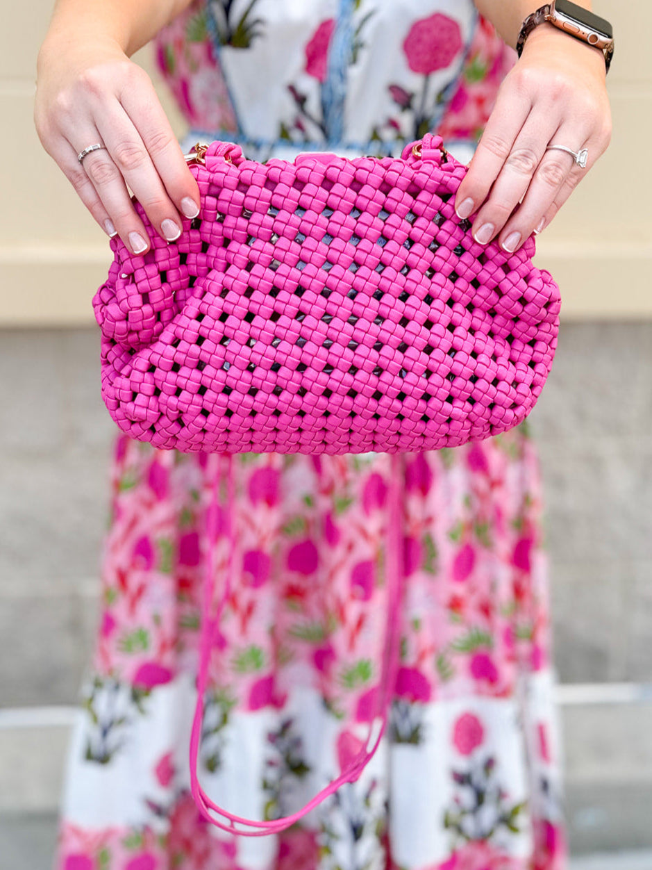 Hot pink woven handbag with a braided texture and knotted strap detail, offering a vibrant and chic everyday style.