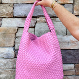 Trendy pink woven handbag with a soft, luxurious texture and modern silhouette—perfect for spring outfits.