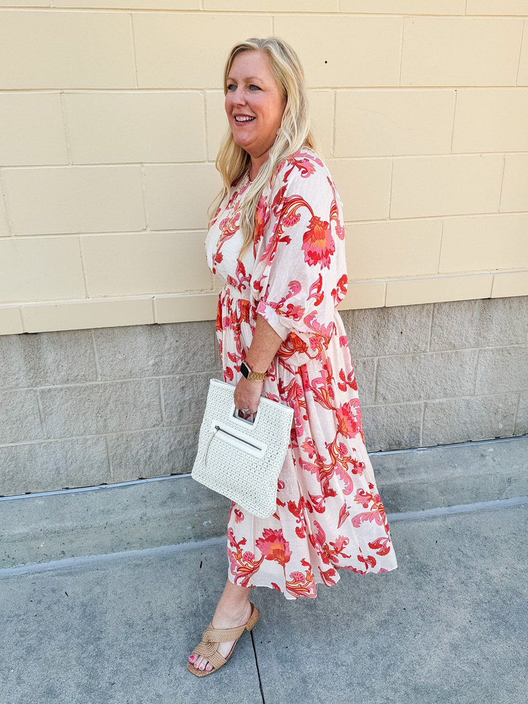Cream midi dress with pink and orange floral print, scoop neckline, elastic waist, and flowy dolman sleeves.