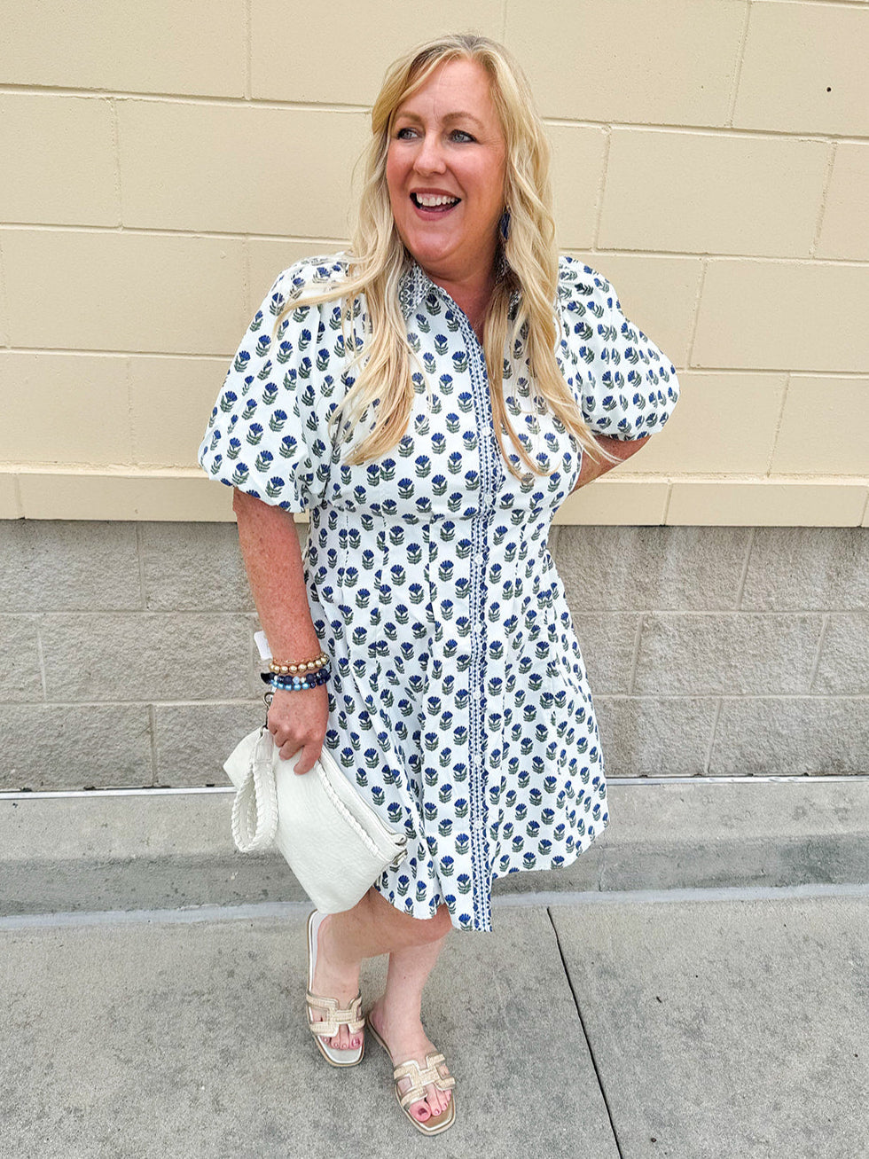 Navy floral dress with puff sleeves, button-down front, and collar
