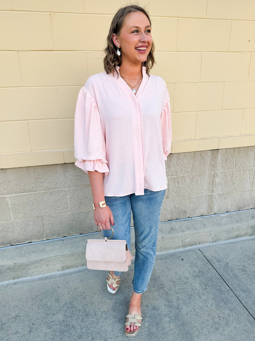Blush blouse with V-neckline, balloon sleeves, front pleat, and ruffle-trimmed cuffs