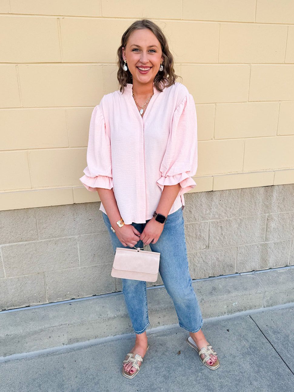 Blush blouse with V-neckline, balloon sleeves, front pleat, and ruffle-trimmed cuffs