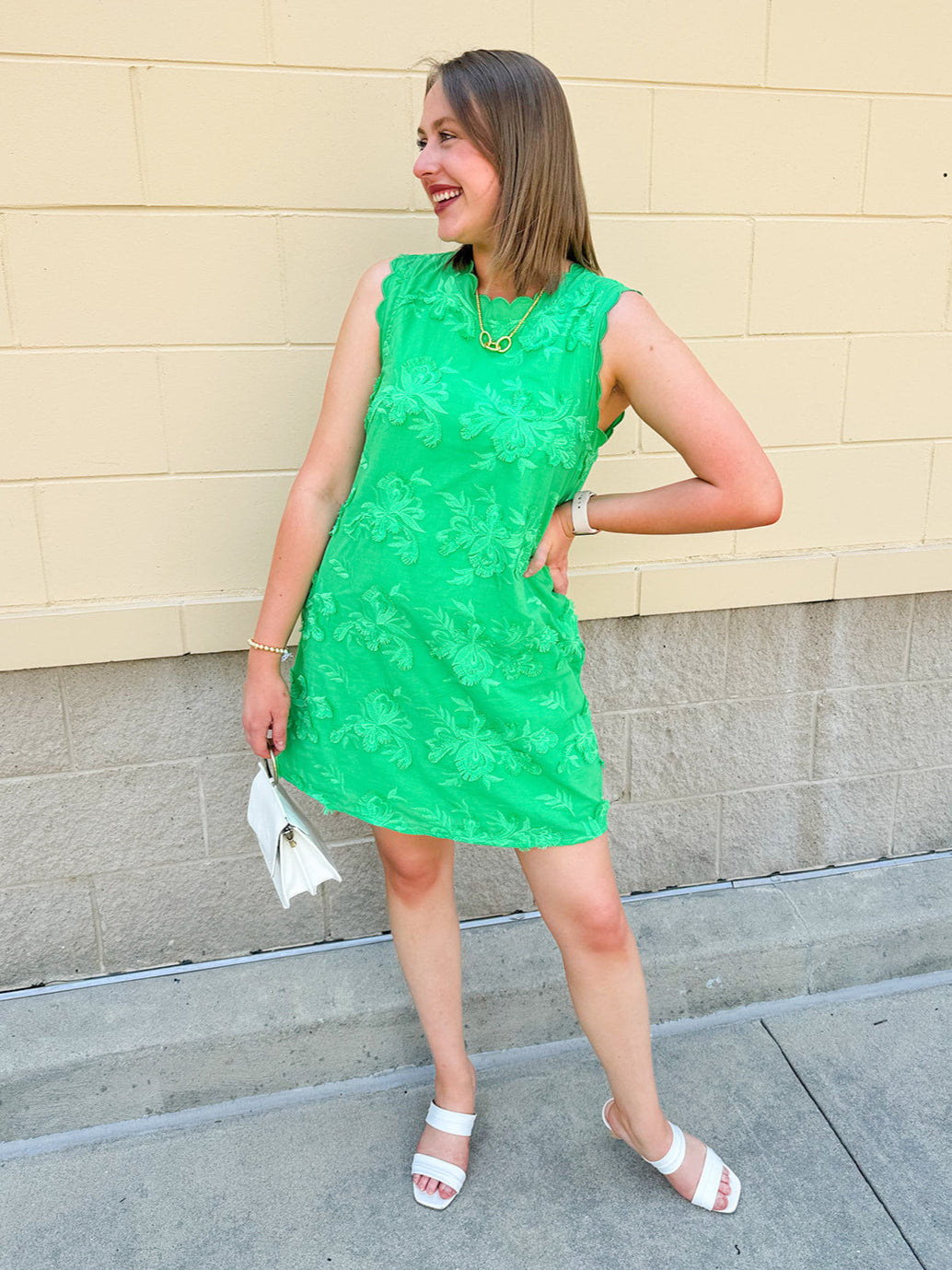 Green sleeveless mini dress with 3D floral appliqués, scalloped hem, and tone-on-tone embroidered details—elegant and lightweight.