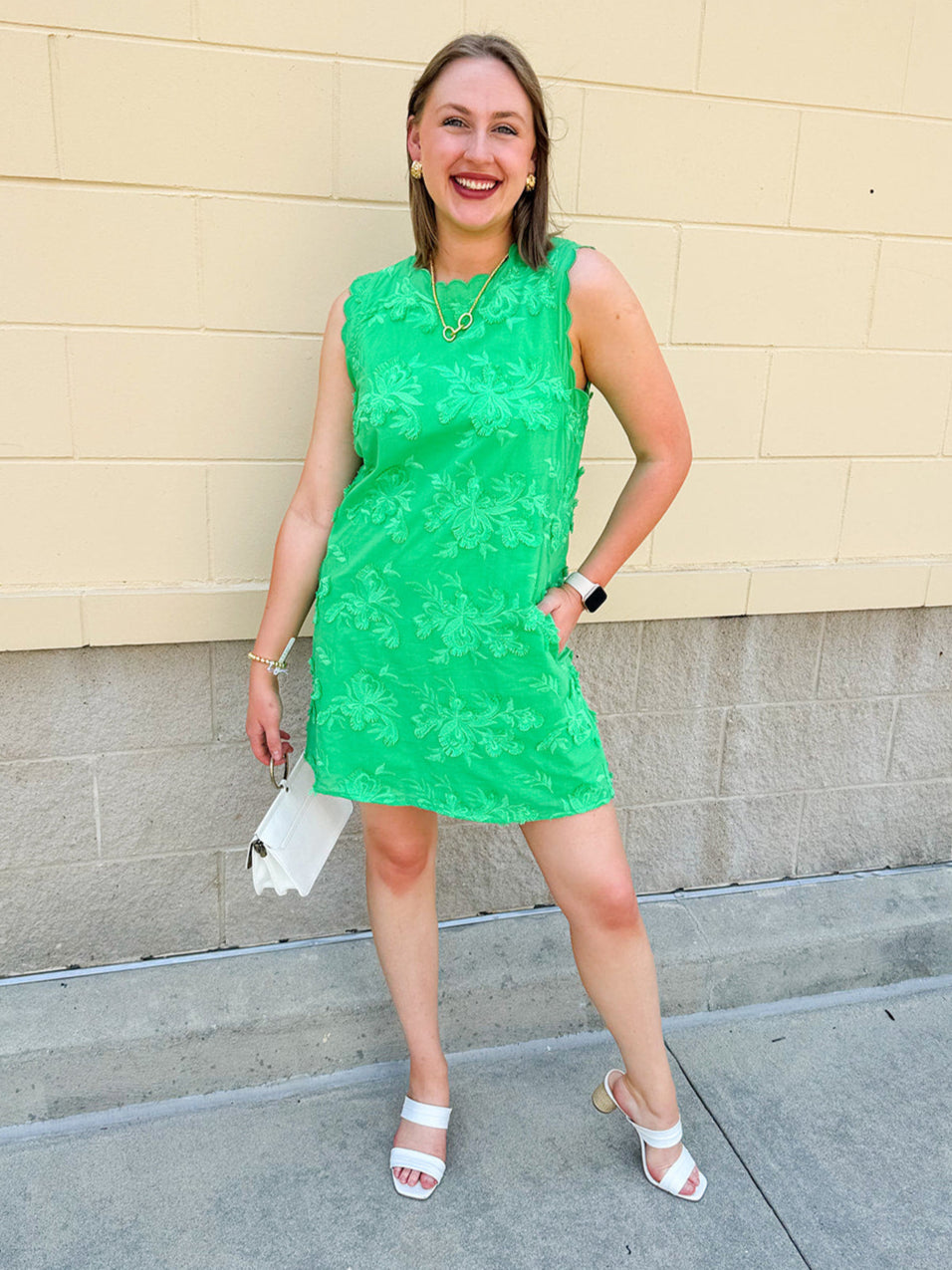 Green sleeveless mini dress with 3D floral appliqués, scalloped hem, and tone-on-tone embroidered details—elegant and lightweight.