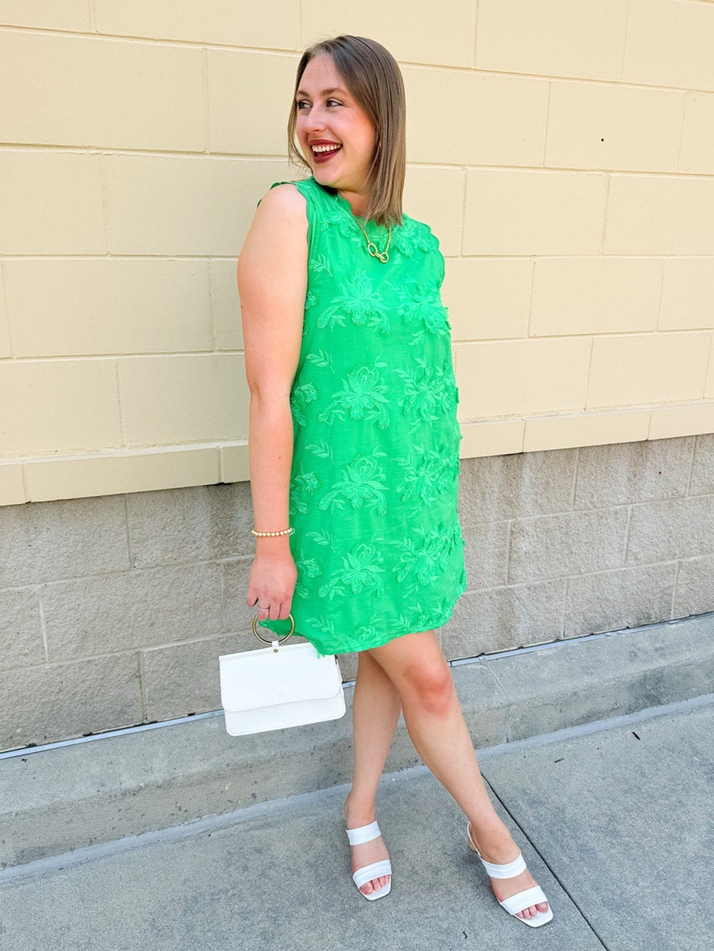 Green sleeveless mini dress with 3D floral appliqués, scalloped hem, and tone-on-tone embroidered details—elegant and lightweight.