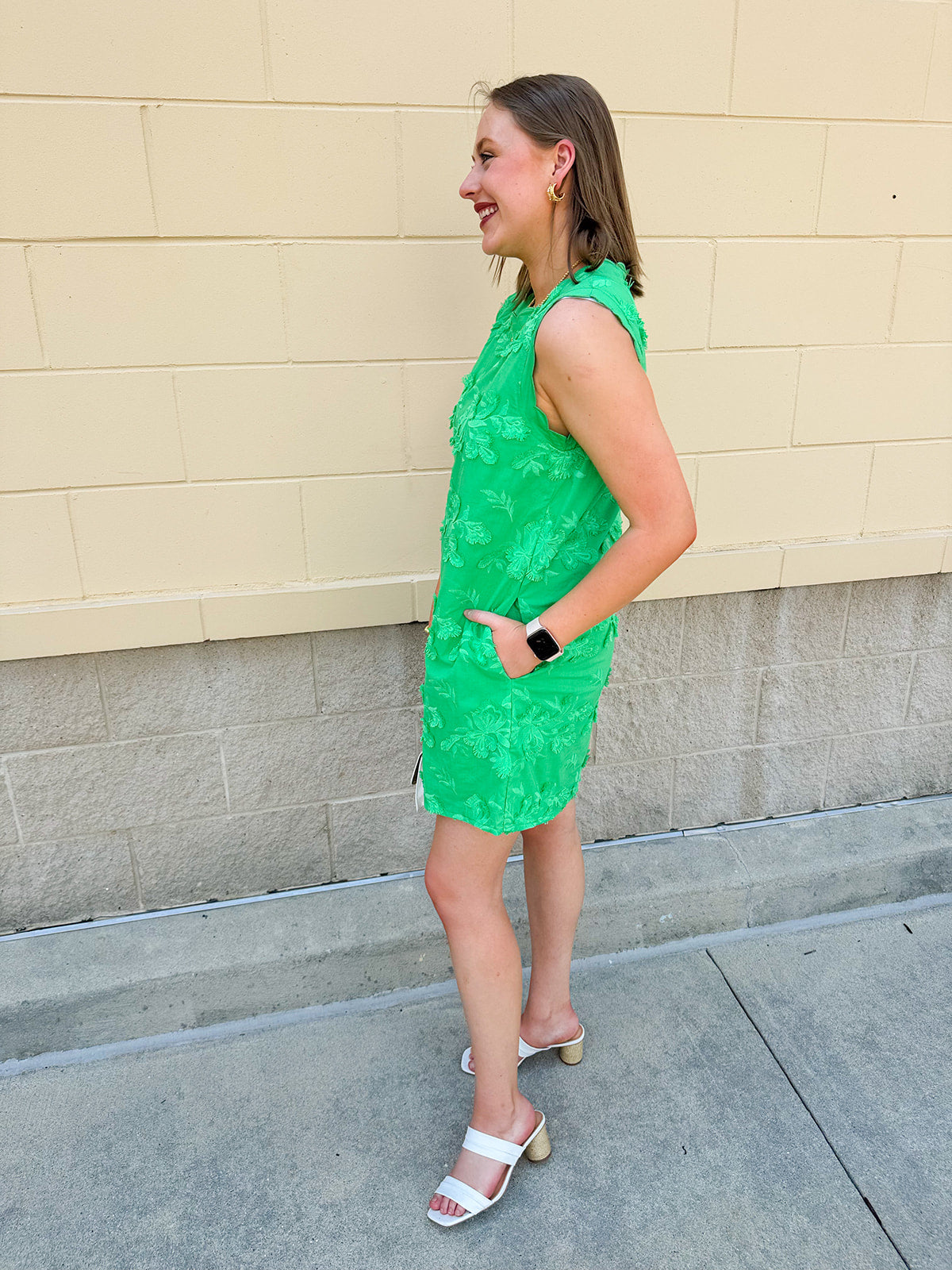 Green sleeveless mini dress with 3D floral appliqués, scalloped hem, and tone-on-tone embroidered details—elegant and lightweight.