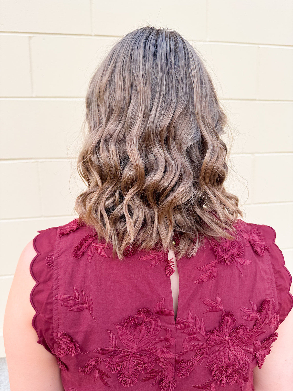 Sleeveless mini dress in rich garnet with 3D floral appliqué, scalloped embroidered hem, and side pockets. Elegant, textured, and perfect for fall or Gameday.