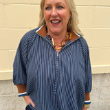 A navy and light blue striped top with camel color block collar and cuffs, styled for fall layering.
