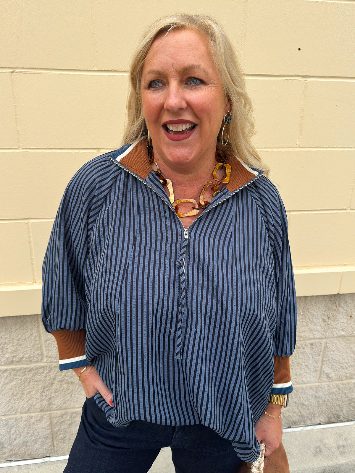 A navy and light blue striped top with camel color block collar and cuffs, styled for fall layering.