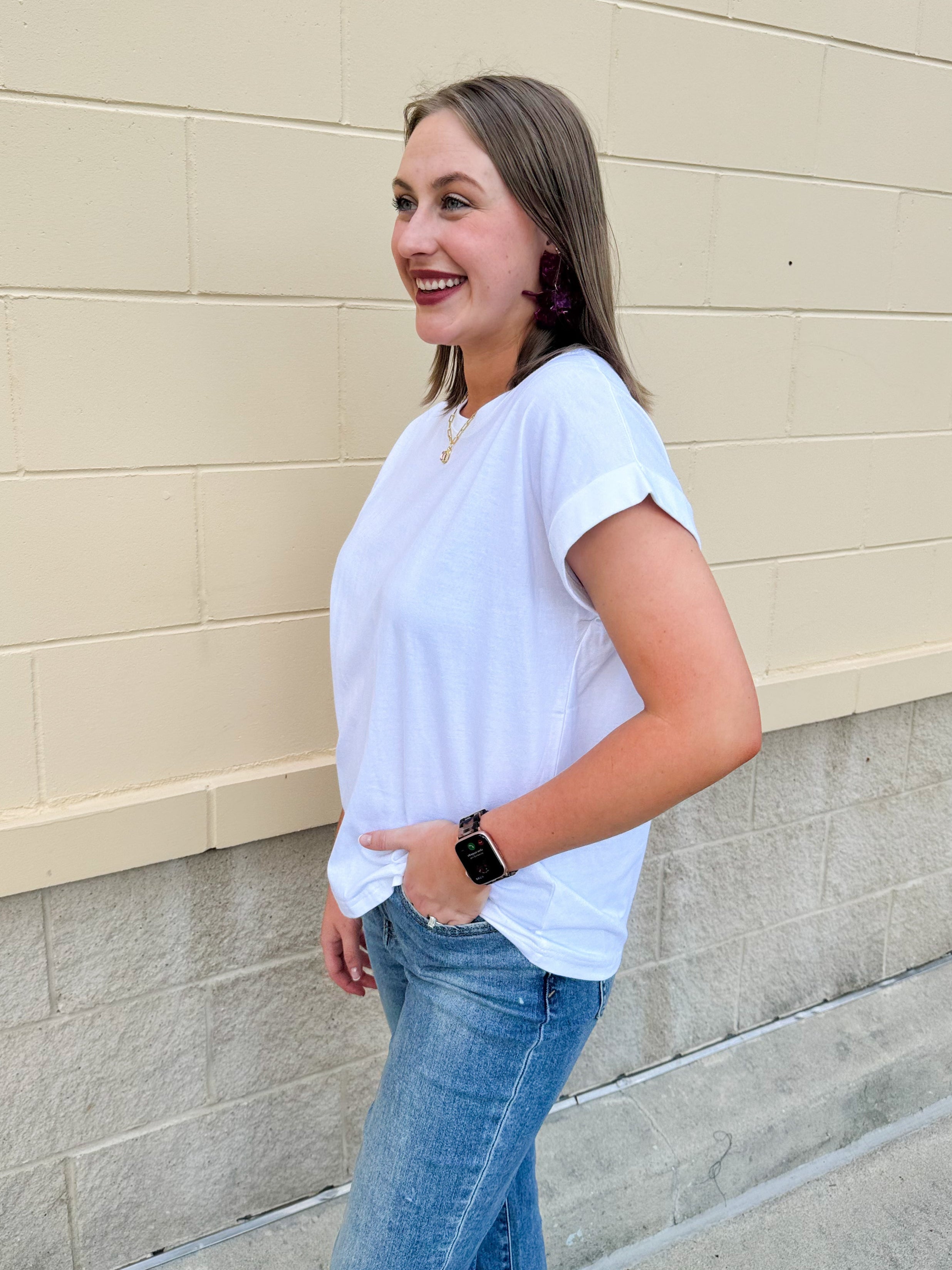 White rolled sleeve tee displayed on hanger or model, showing relaxed fit and classic style.