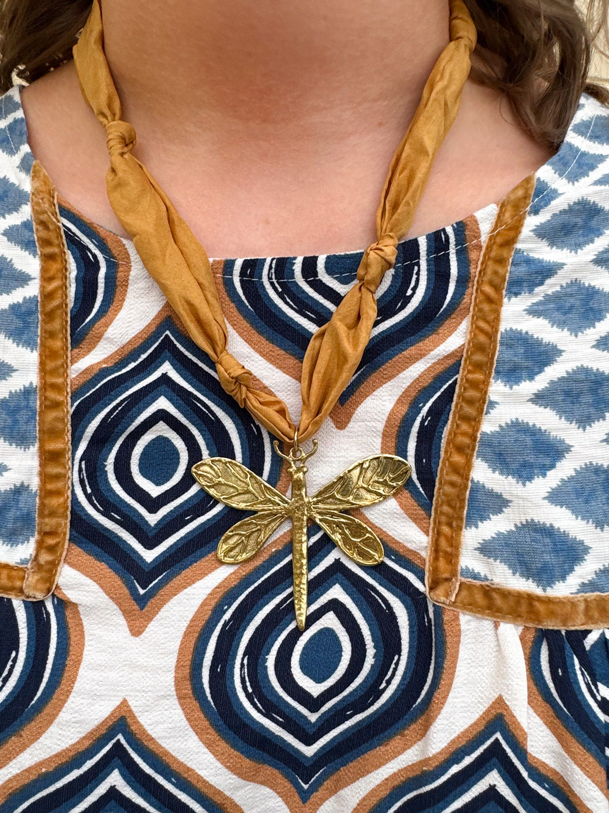 Camel scarf-style necklace with gold metal dragonfly pendant, handmade by Hart Designs.