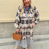 Tiered midi dress in fall blues, creams, and browns with ruffled collar and button-down placket.