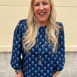 Blue floral print blouse with jewel neckline, back keyhole, and elastic puff sleeves.