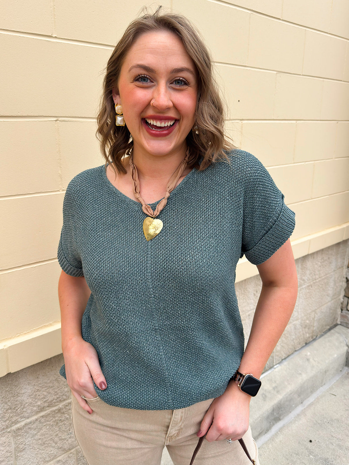 Ash jade short-sleeve lightweight sweater with center seam, rolled cuffs, and side slits.