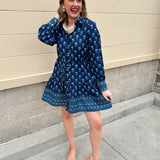 Blue floral print mini shirt dress with long sleeves, button cuffs, and removable belt