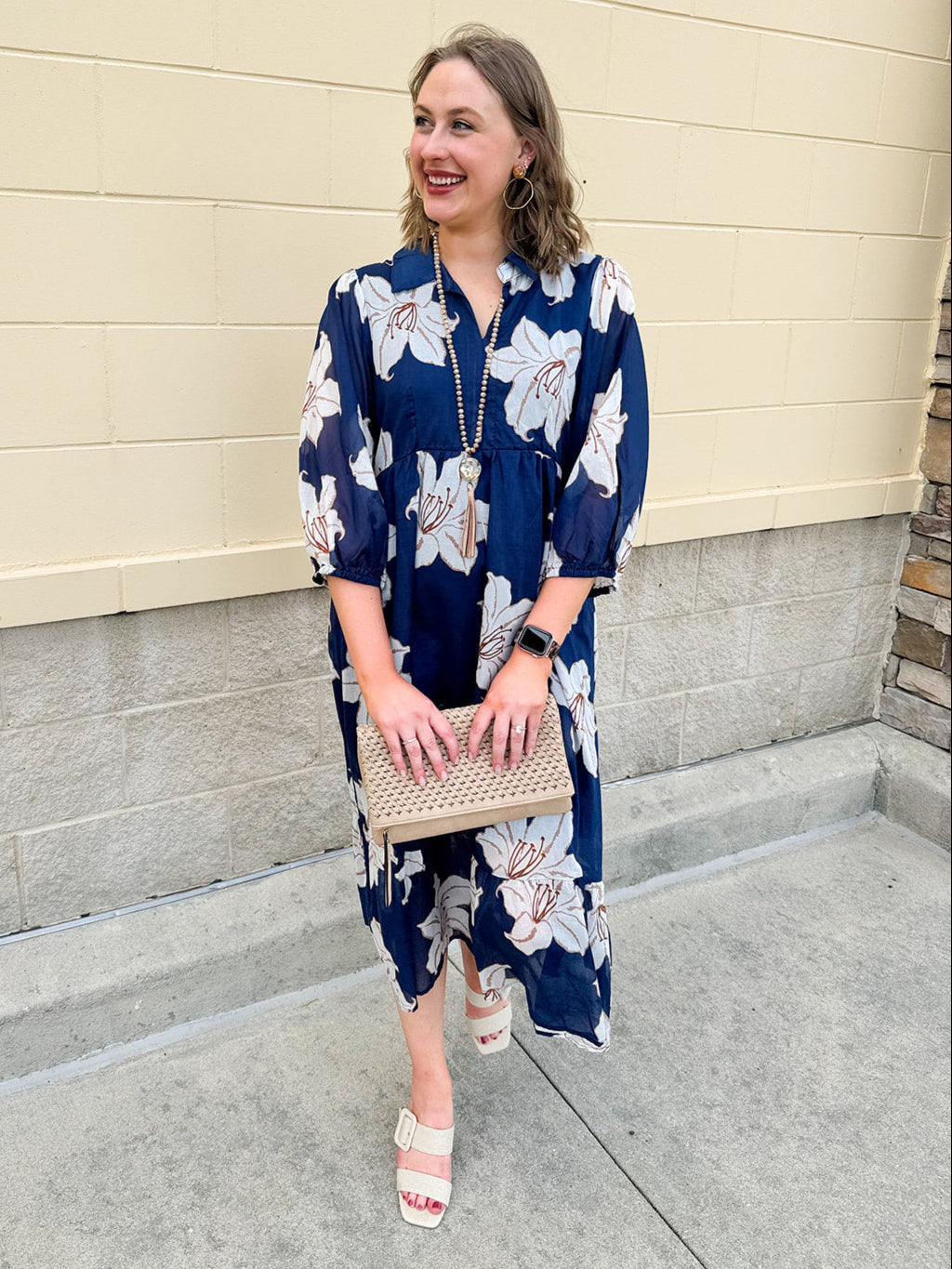 Navy midi dress with white floral details, collar, and 3/4-length sleeves