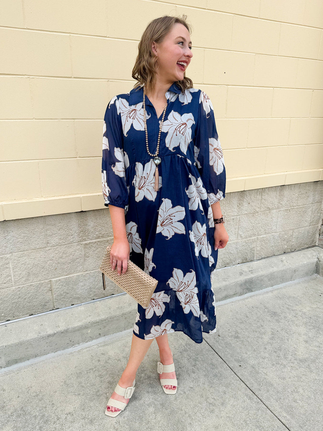 Navy midi dress with white floral details, collar, and 3/4-length sleeves