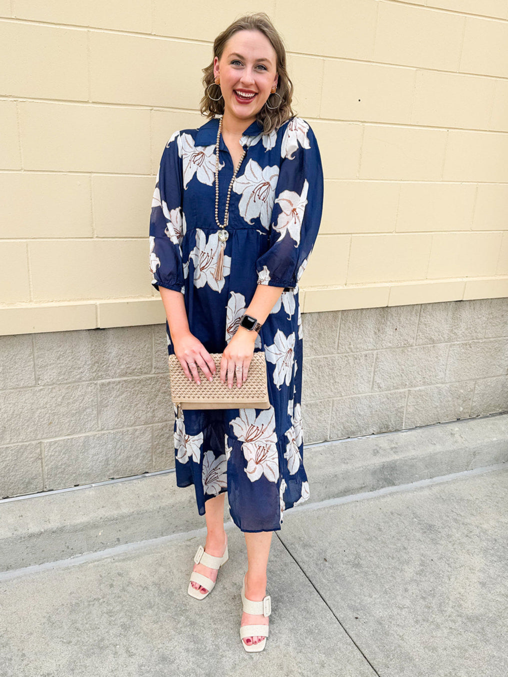 Navy midi dress with white floral details, collar, and 3/4-length sleeves