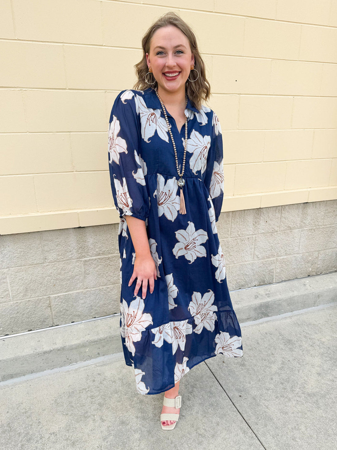 Navy midi dress with white floral details, collar, and 3/4-length sleeves