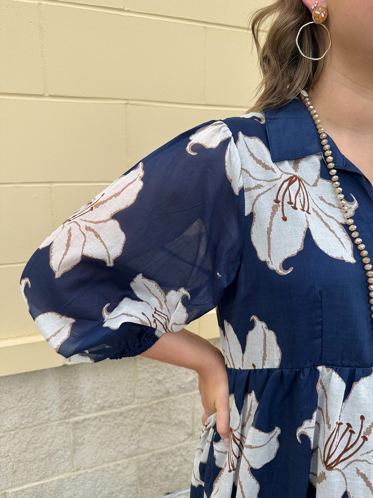 Navy midi dress with white floral details, collar, and 3/4-length sleeves