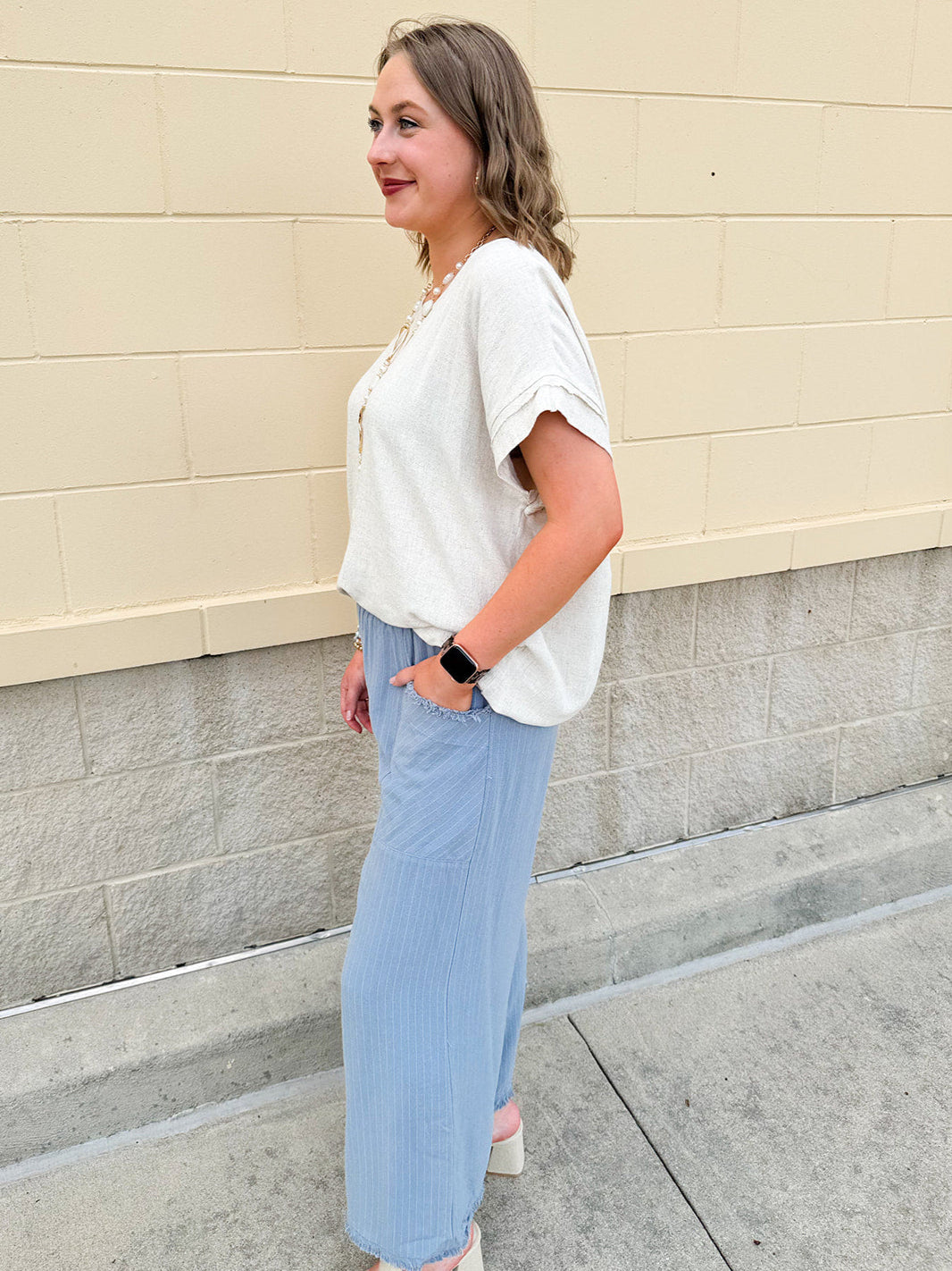 Linen-cotton blend short-sleeve top with front tie and raw hem in a soft neutral oatmeal shade.