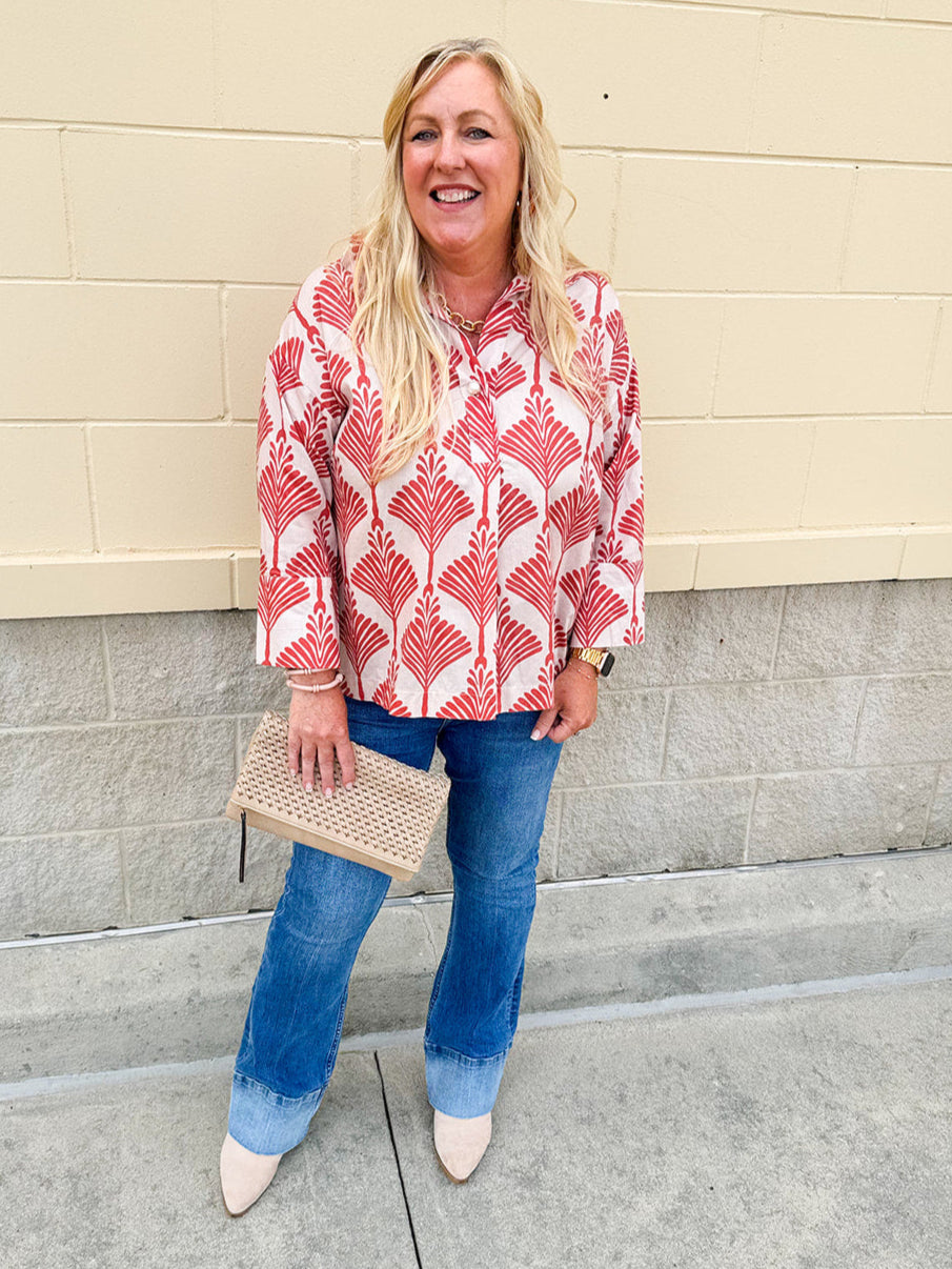 Cream shirt with rust pattern, collar, one button, and ¾-length cuffed sleeves