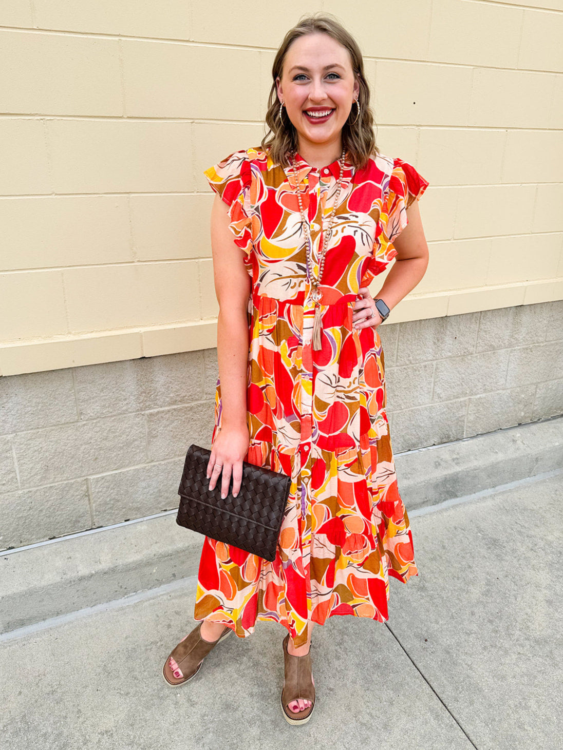 Collared midi dress with red, cream, and green pattern, ruffle sleeves, and buttons down front