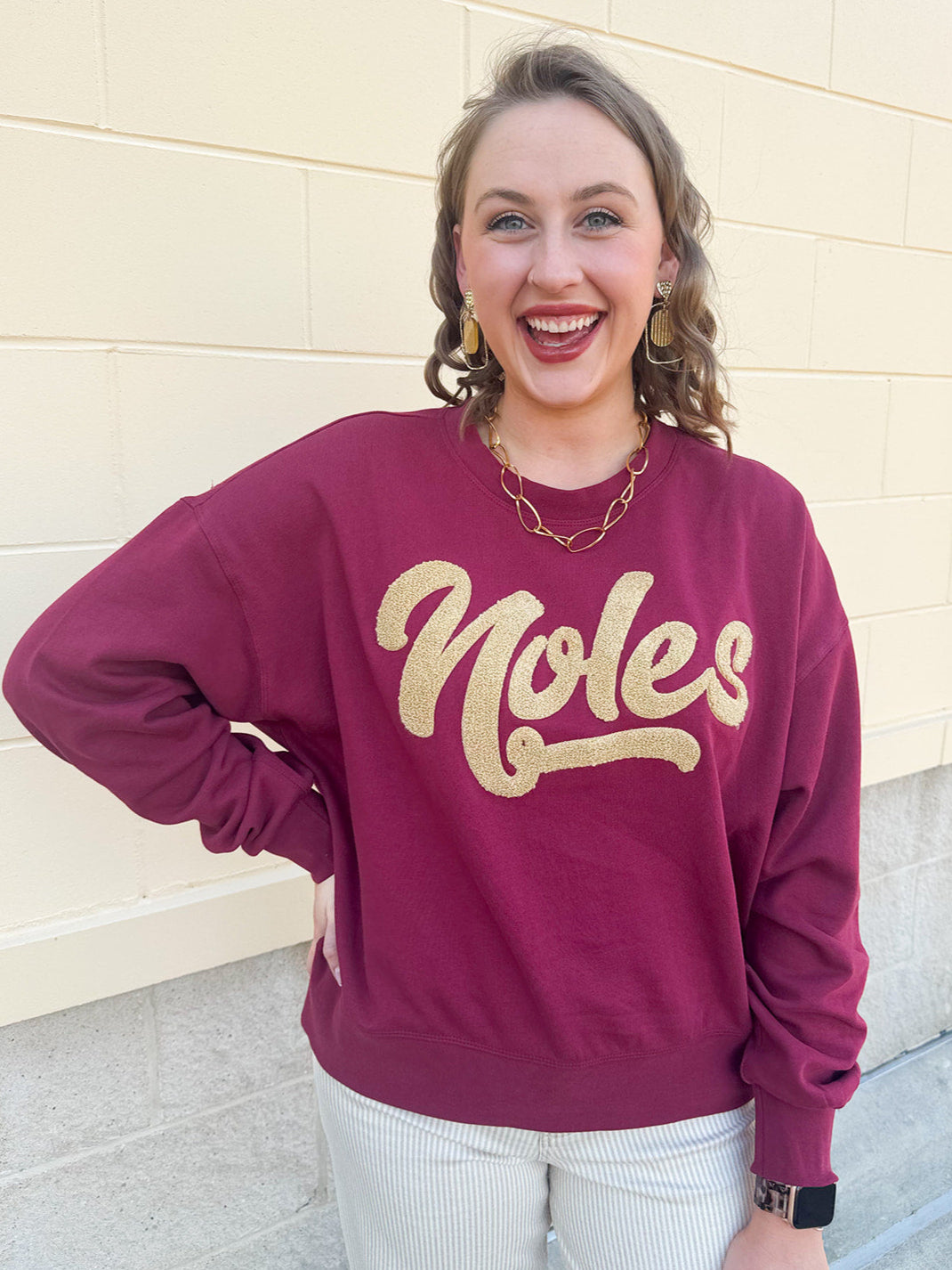 Garnet crewneck sweatshirt with dropped shoulders and gold chenille “Noles” script lettering.