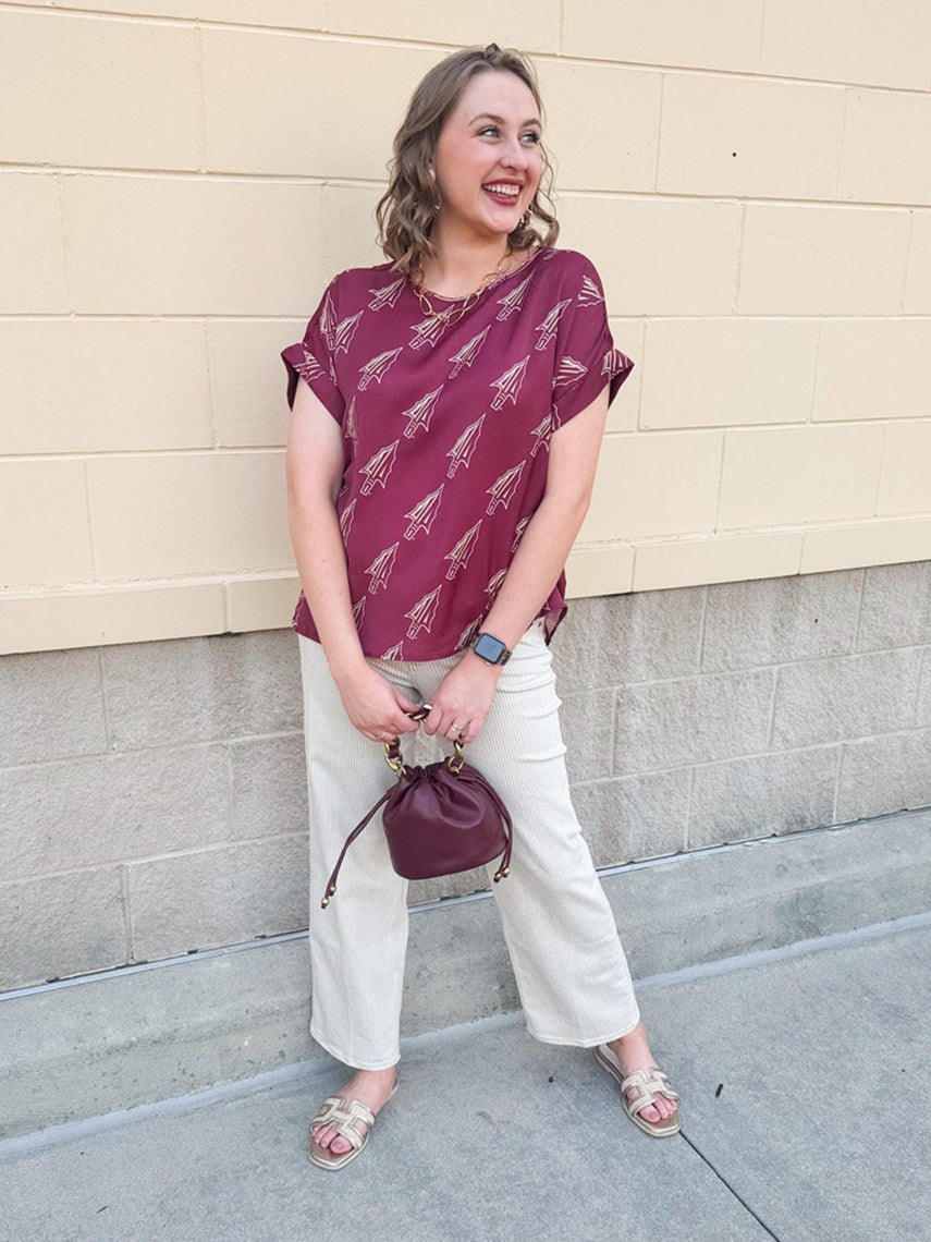 Garnet rolled cuff blouse with allover gold spear pattern, short sleeves, and boxy fit.