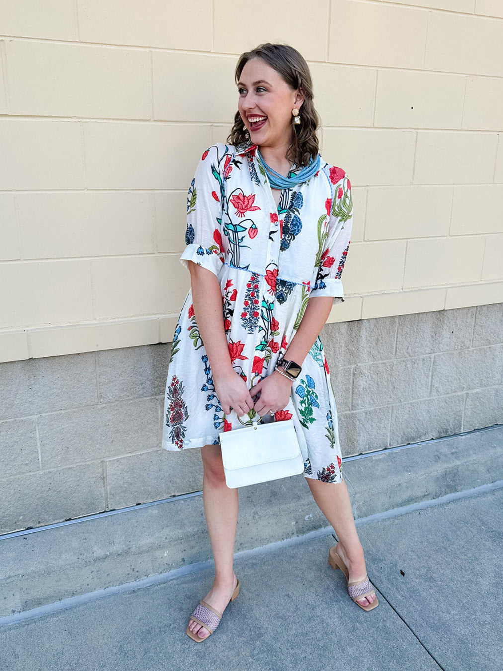 White mini shirt dress with button-down front, collar, ¾ sleeves, and striped piping details.