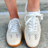 Neutral woven low-top sneakers with muted laces, round toe, and 1-inch heel, styled for casual and fashion-forward everyday looks.