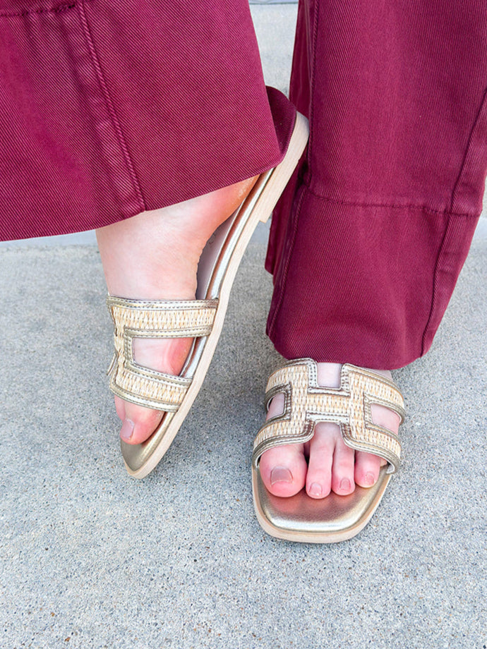 Ena Raffia H-Cutout Slides featuring a breathable raffia strap and modern H-cutout design, styled on a clean surface to showcase their chic, casual summer look and cushioned footbed