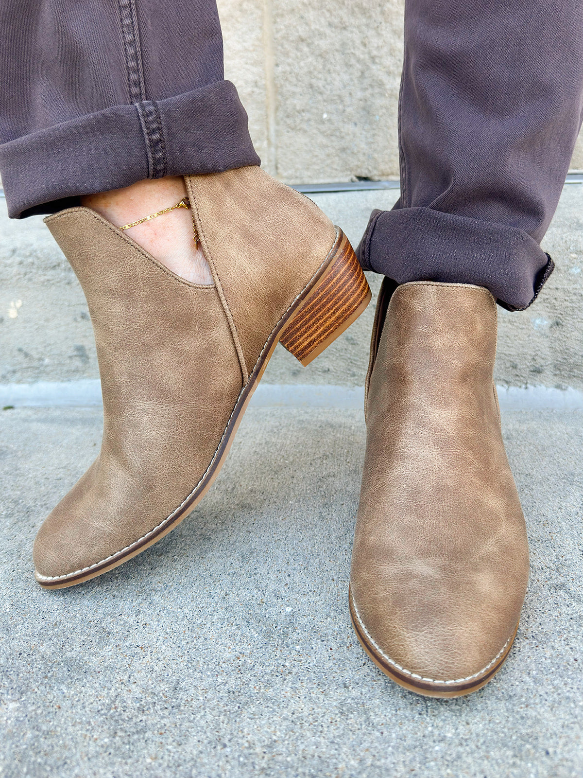 Taupe faux leather ankle booties with side cutouts, back zipper, and block heel.
