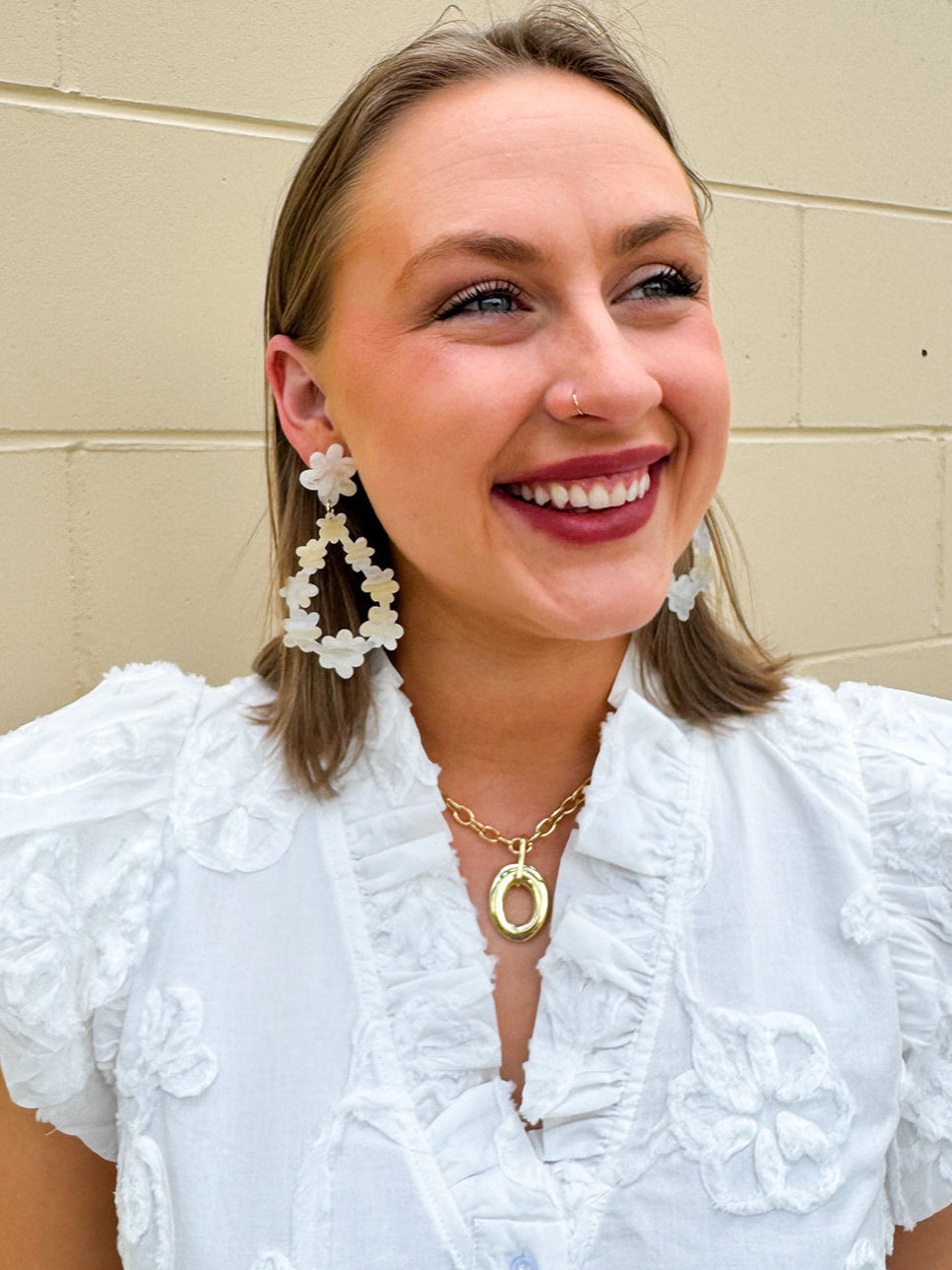 Oversized glittery earrings with a creamy base and swirls of gold and silver, styled for a bold and playful celestial look.