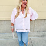 Solid pink button-down blouse with circular eyelet trim, ¾ sleeves, and pleated details, styled for a refined, feminine look.