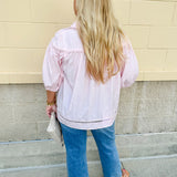 Solid pink button-down blouse with circular eyelet trim, ¾ sleeves, and pleated details, styled for a refined, feminine look.