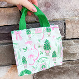 Small tote bag with Christmas-themed design featuring trees, wreaths, and presents on a white background.