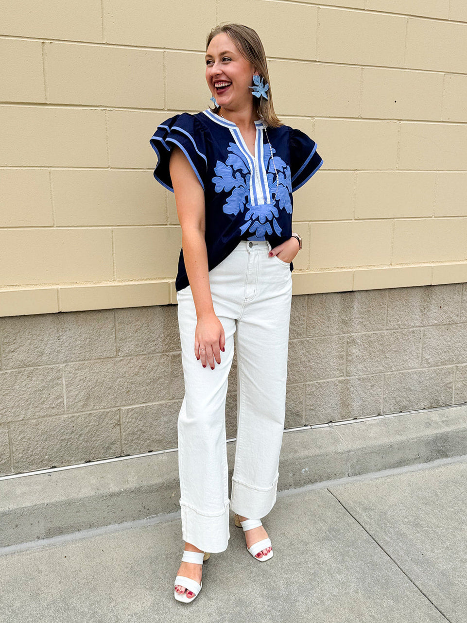 Navy embroidered flutter sleeve top with multicolor appliqué and V-neckline—lightweight and versatile for everyday wear