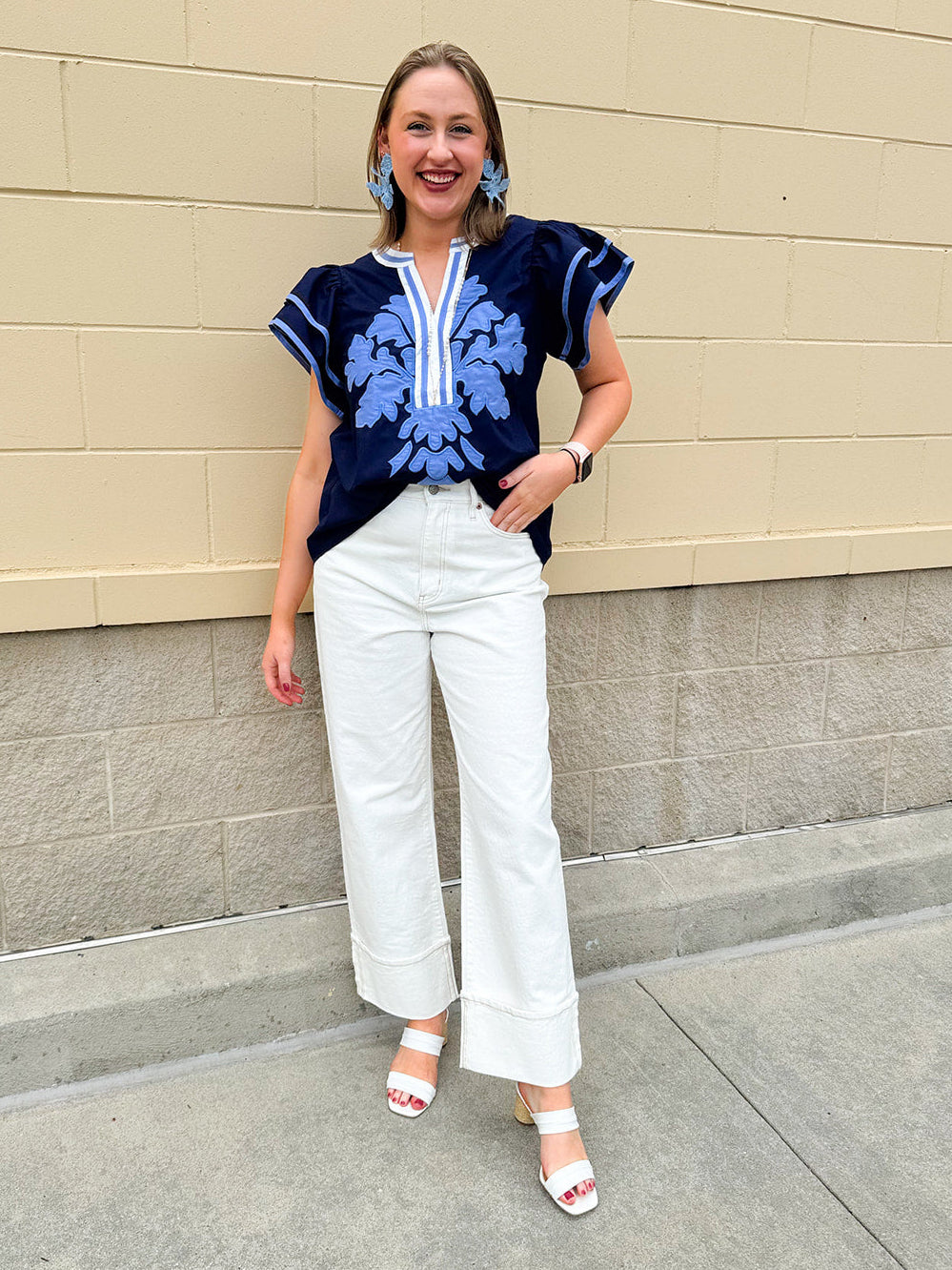 Navy embroidered flutter sleeve top with multicolor appliqué and V-neckline—lightweight and versatile for everyday wear