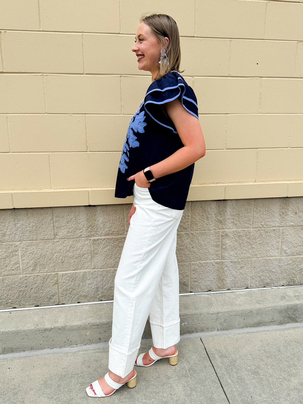 Navy embroidered flutter sleeve top with multicolor appliqué and V-neckline—lightweight and versatile for everyday wear