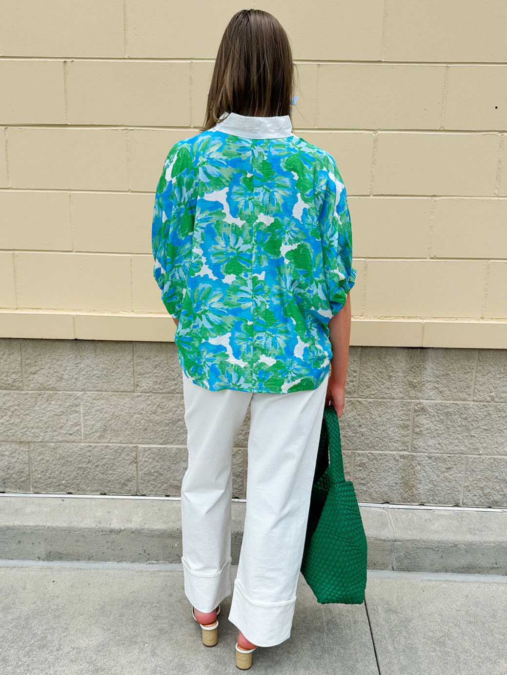 White caftan top with green and blue abstract floral print, split neckline, and dolman sleeves with elastic cuffs—lightweight and flowy