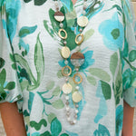 Long oatmeal-colored necklace with mixed circle and bead design, featuring neutral stones and delicate chain