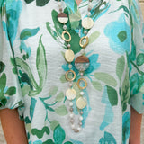 Long oatmeal-colored necklace with mixed circle and bead design, featuring neutral stones and delicate chain