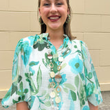 Long oatmeal-colored necklace with mixed circle and bead design, featuring neutral stones and delicate chain