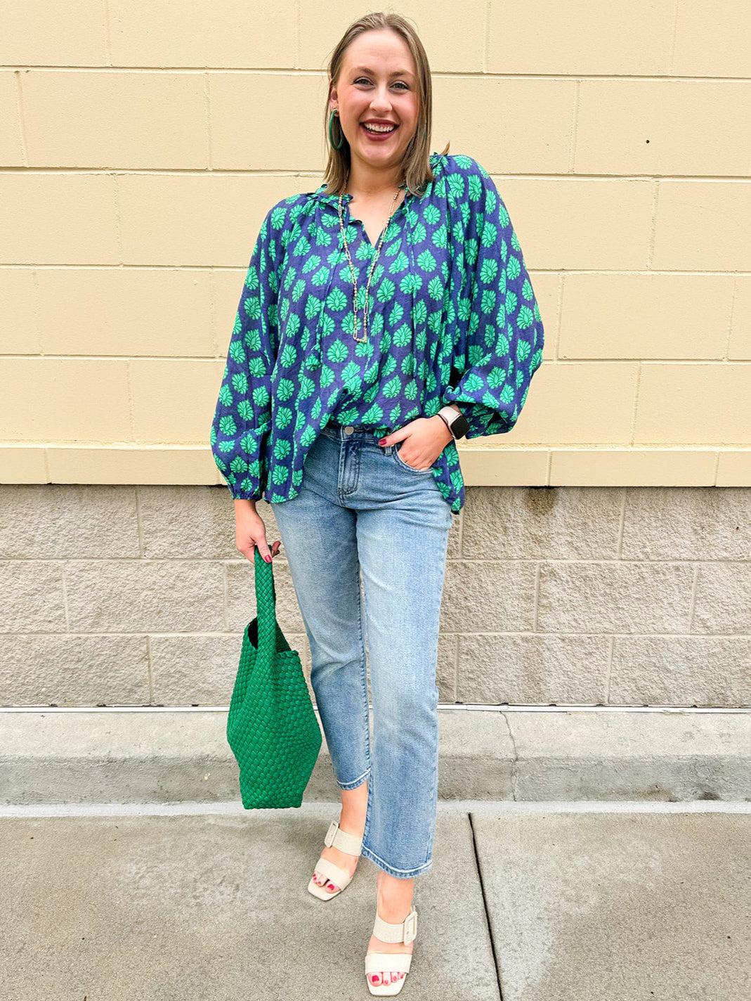 Flowy navy and green patterned blouse with tie-neck, ruffle collar, dolman sleeves, and elastic cuffs—lightweight and oversized
