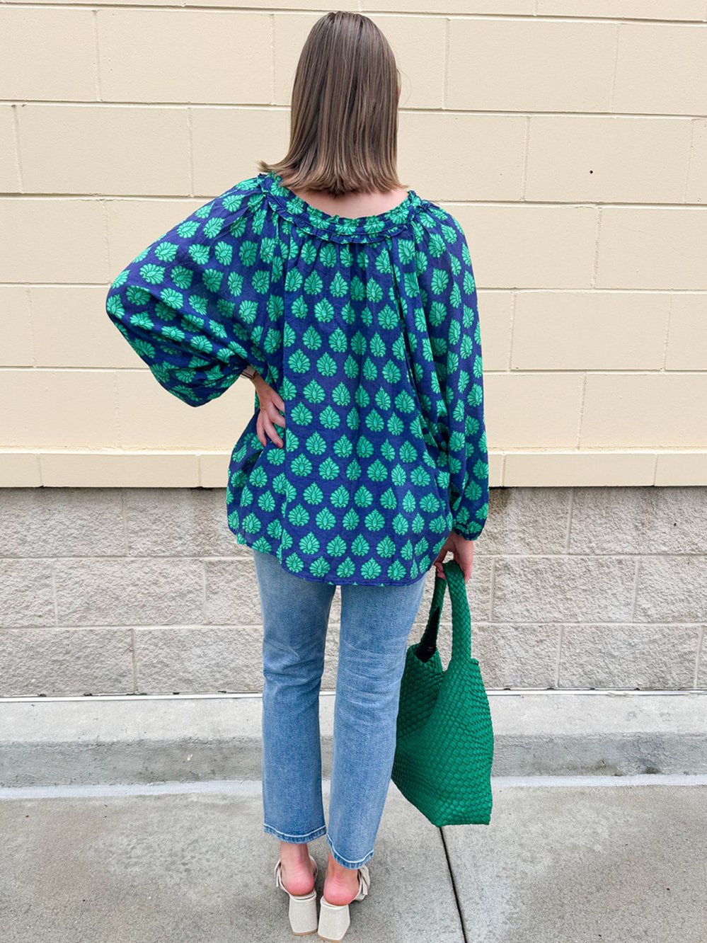 Flowy navy and green patterned blouse with tie-neck, ruffle collar, dolman sleeves, and elastic cuffs—lightweight and oversized